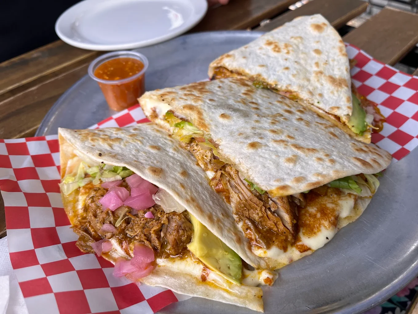 A tray of stuffed quesadillas with avocado, cheese and pickled onions